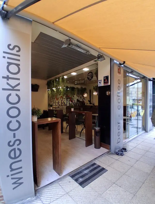 Entrada del local con los carteles de «wines · cocktails» y «beer · coffee»